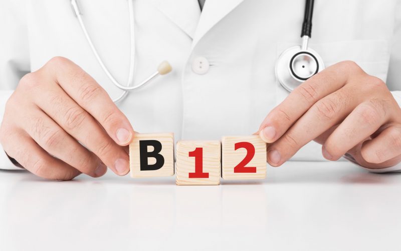 Doctor holds wooden cubes in his hands with text B12